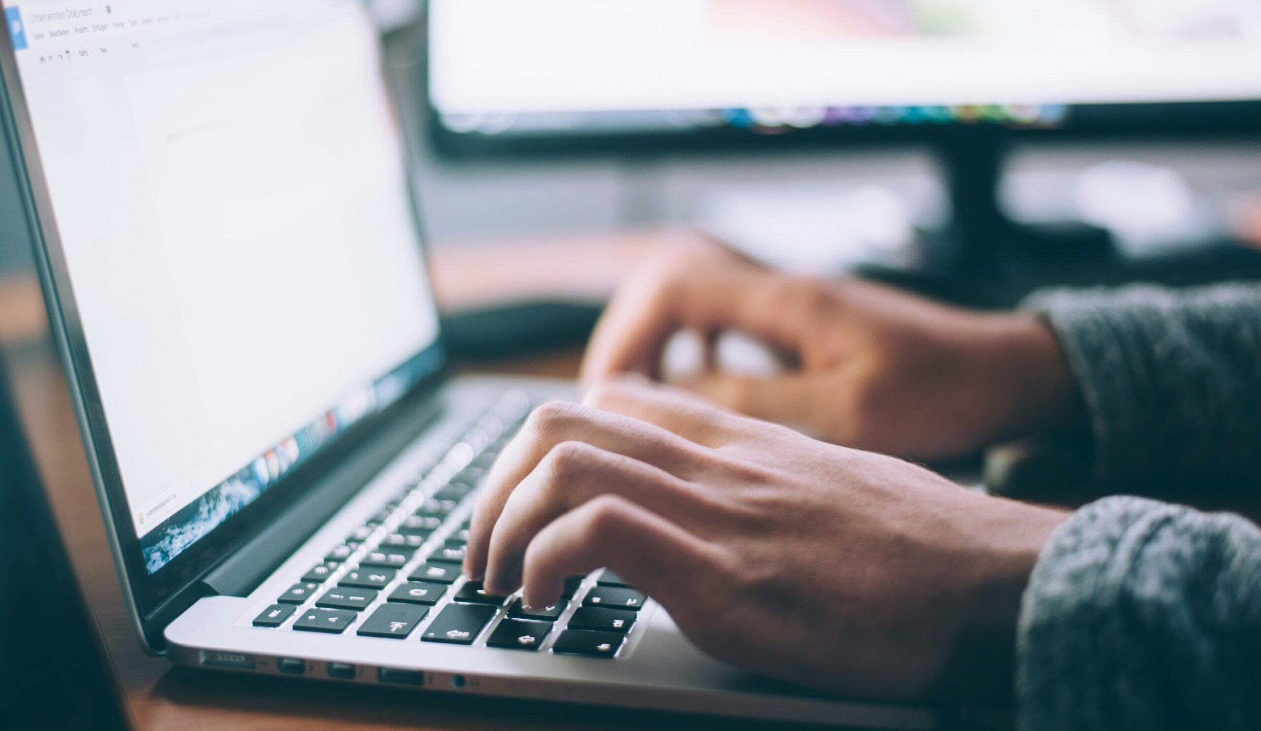 man typing on laptop